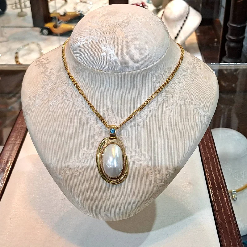 Ladies Necklaces Pearl Glow-Necklace with a 18k gold medallion mother of pearl and a bleu topaz in a hand made 18k. gold chain